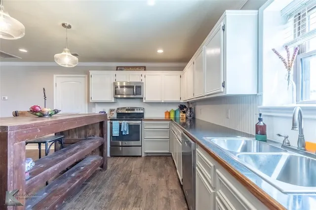 a kitchen with stainless steel appliances granite countertop a sink and cabinets