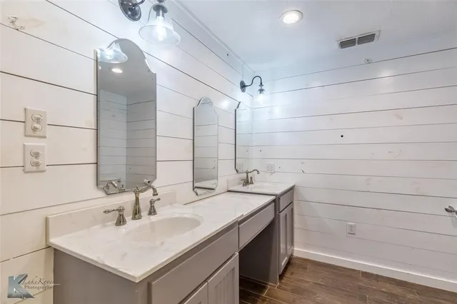 a bathroom with a sink shower and a mirror