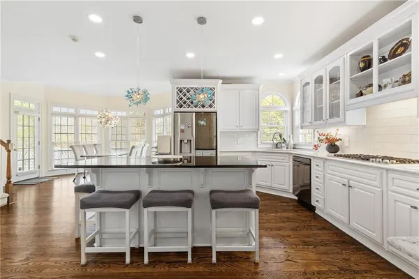 a kitchen with stainless steel appliances granite countertop a refrigerator and a stove top oven
