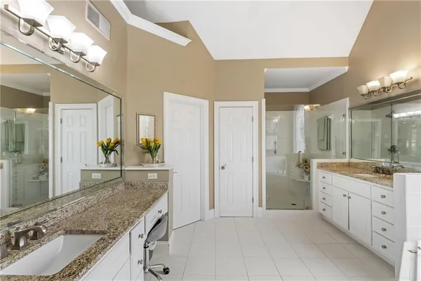 a bathroom with double vanity sinks and a mirror