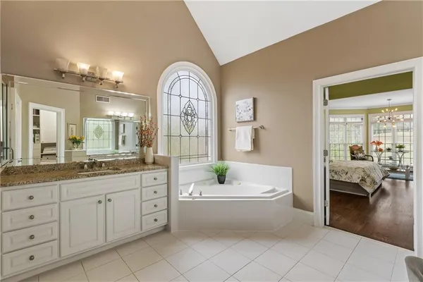 a spacious bedroom with a bed and a chandelier