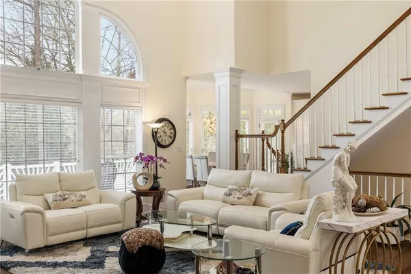 a living room with furniture a couch and a large window