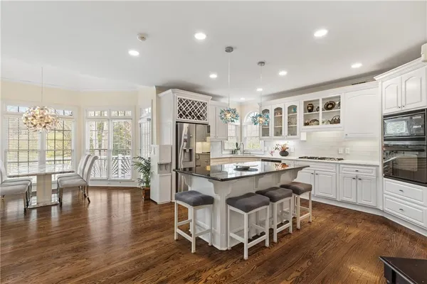 a kitchen with stainless steel appliances granite countertop a stove top oven a sink a counter space and cabinets