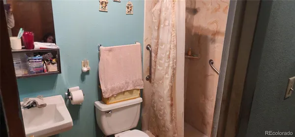 a bathroom with a toilet and a shower curtain