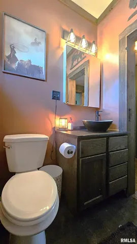 a bathroom with a toilet a sink and mirror