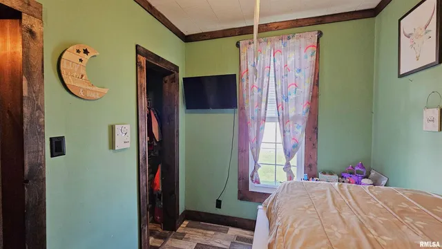 a bedroom with a bed a mirror and a window