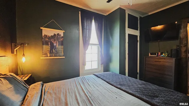 a bedroom with a bed and lamp on the dresser