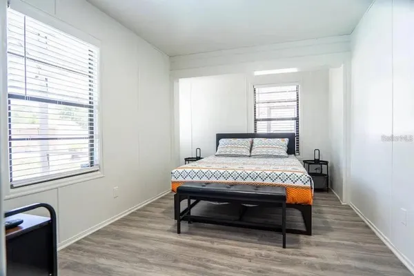 a bedroom with a bed a flat screen tv and window