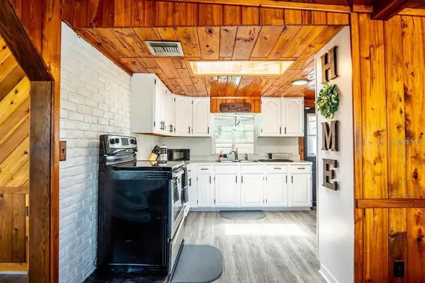 a kitchen with stainless steel appliances granite countertop a stove and white cabinets