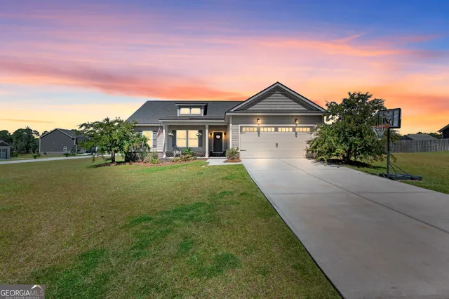 a front view of a house with yard and green space