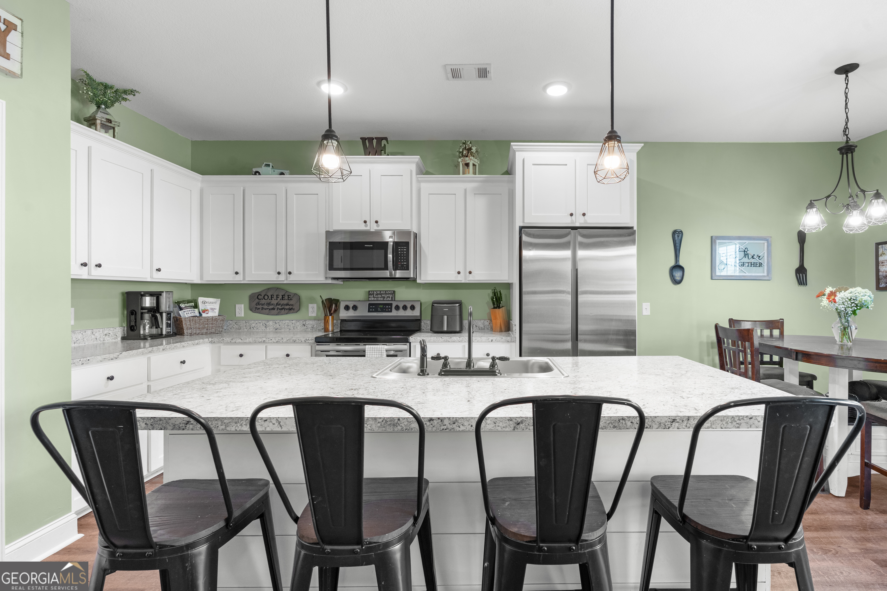 321 Farmington Road Statesboro, GA 30458 - Photo 11 of 24 a kitchen with stainless steel appliances kitchen island granite countertop a dining table chairs refrigerator and microwave