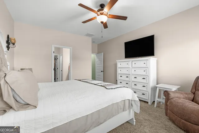 a bedroom with a bed a chandelier and a television