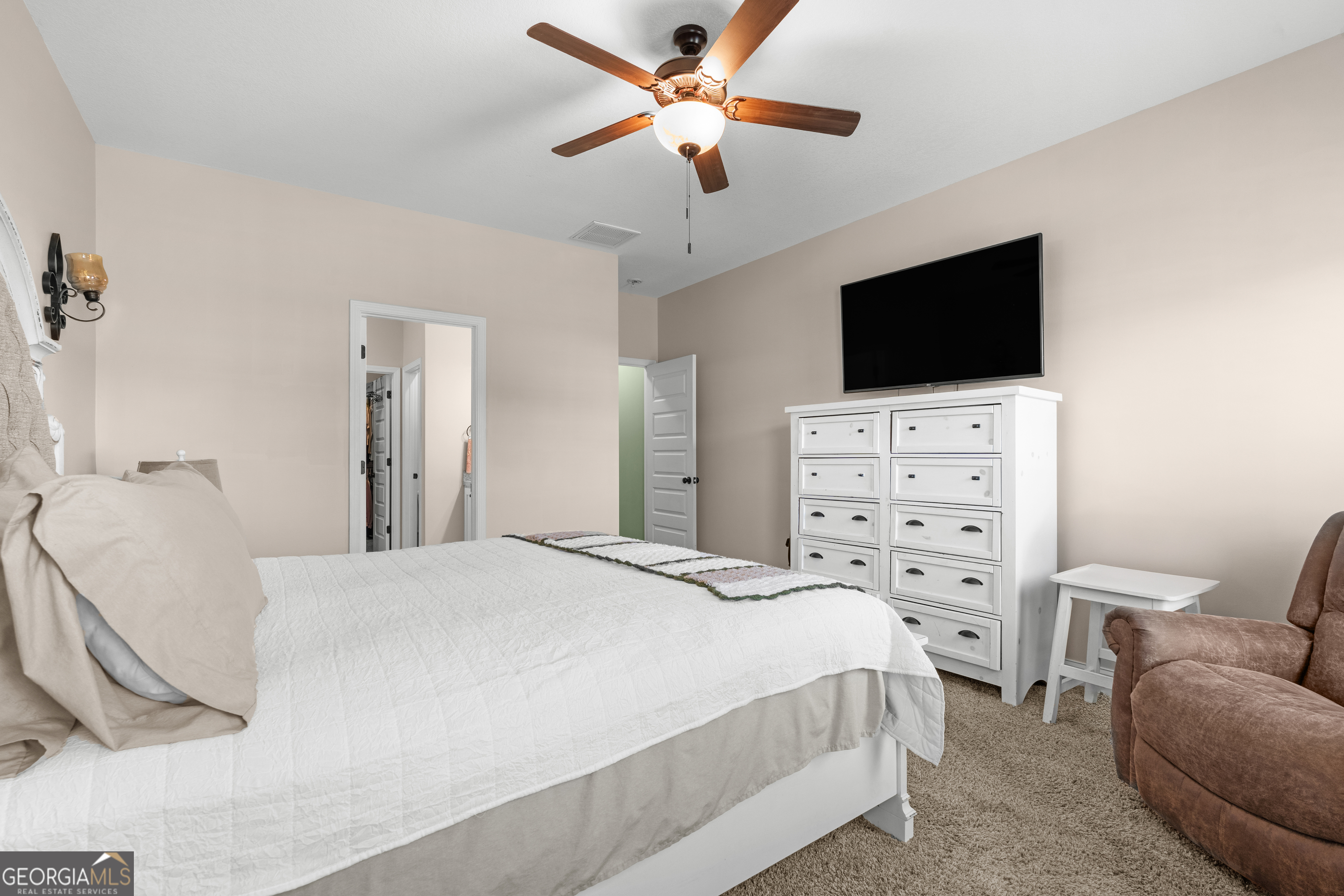 321 Farmington Road Statesboro, GA 30458 - Photo 13 of 24 a bedroom with a bed a chandelier and a television