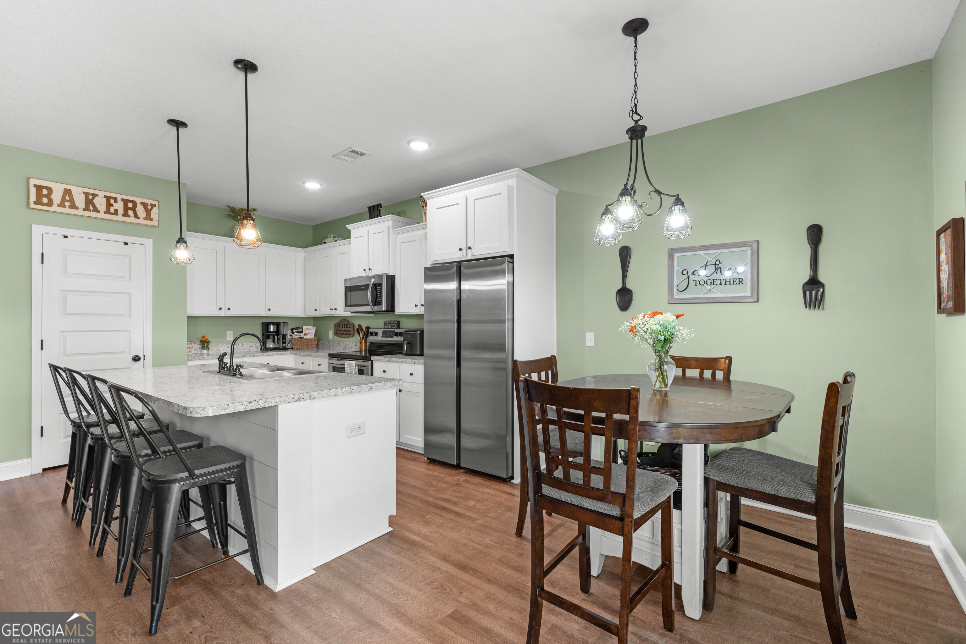 321 Farmington Road Statesboro, GA 30458 - Photo 10 of 24 a kitchen with stainless steel appliances kitchen island granite countertop a dining table chairs and white cabinets