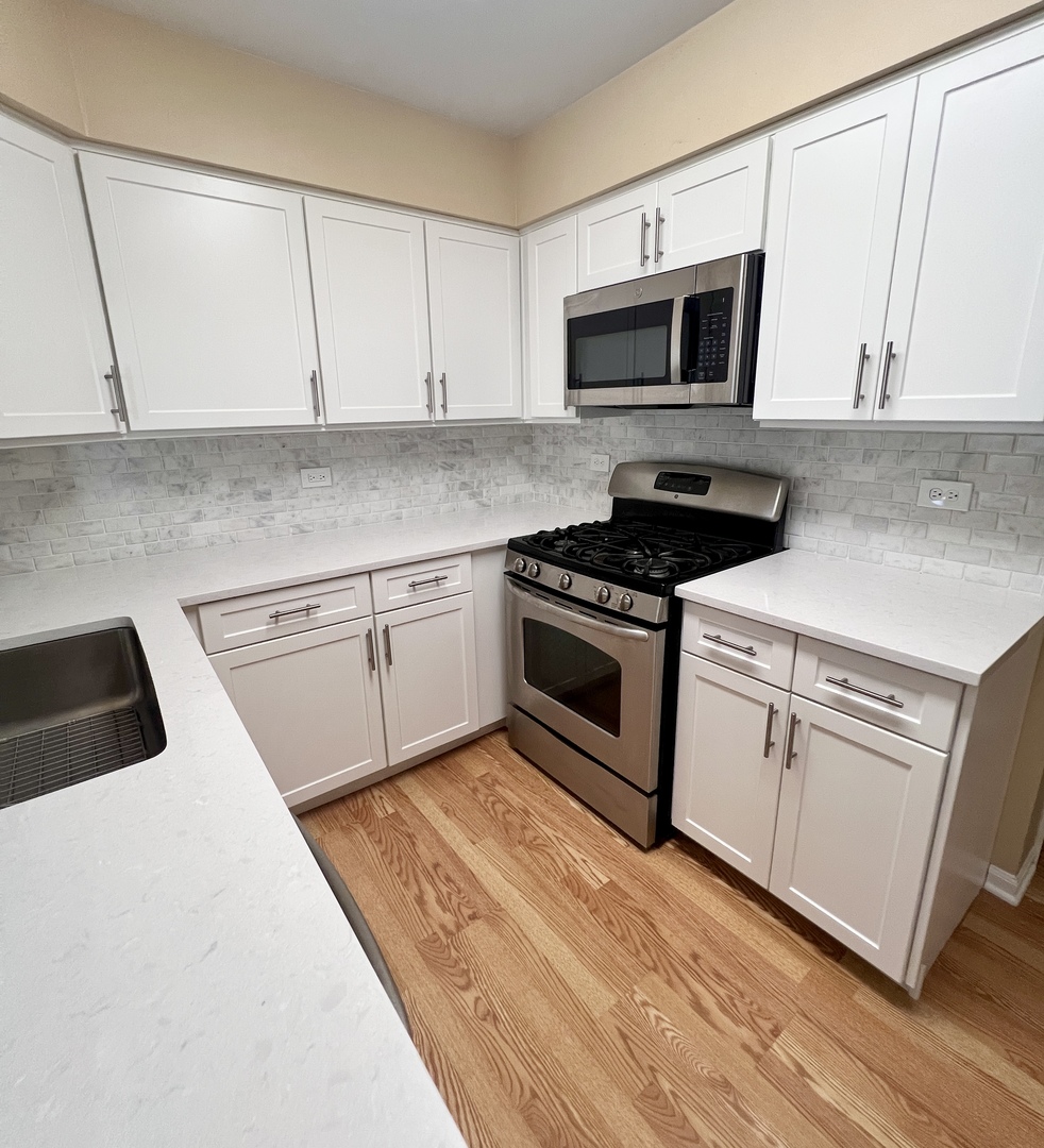 4716 Amber Circle Hoffman Estates, IL 60192 - Photo 7 of 14 a kitchen with granite countertop a stove top oven and cabinets