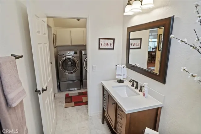 a bedroom with a bed couch chandelier and a window