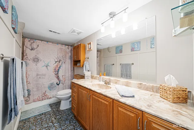 a bathroom with a granite countertop sink toilet and shower