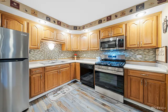 a kitchen with stainless steel appliances granite countertop a stove a sink and a refrigerator