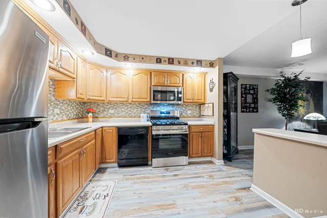 a kitchen with stainless steel appliances granite countertop a stove a sink and a refrigerator