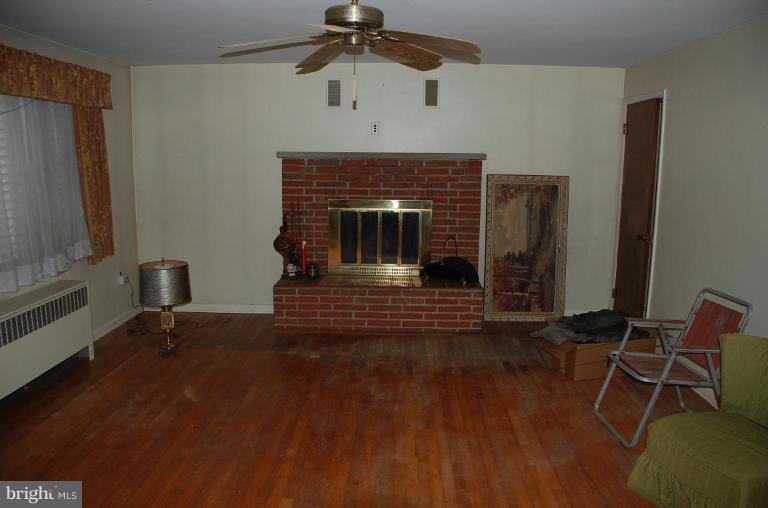 334 Wye Road Essex, MD 21221 - Photo 4 of 7 a living room with a fireplace and a ceiling fan