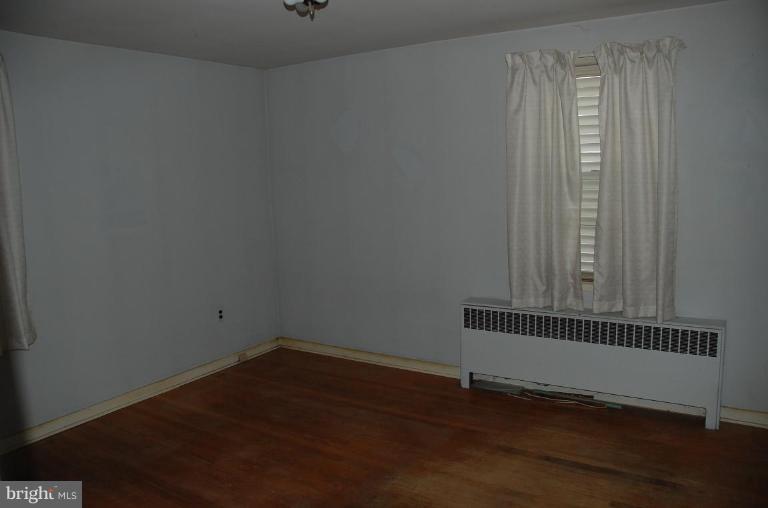334 Wye Road Essex, MD 21221 - Photo 7 of 7 an empty room with wooden floor and windows