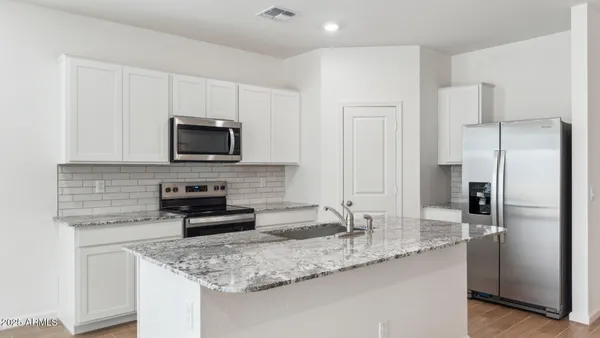 a kitchen with stainless steel appliances granite countertop a sink stove and refrigerator