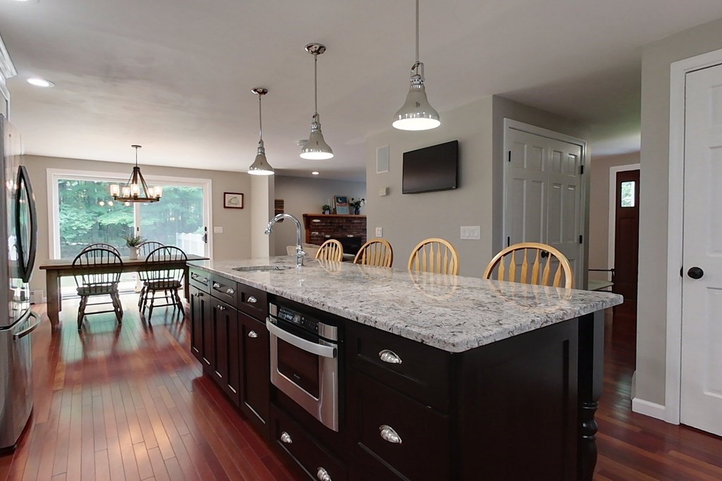 170 South Row Road Townsend, MA 01469 - Photo 5 of 42 a kitchen with stainless steel appliances granite countertop a stove a sink dishwasher a dining table with wooden floor