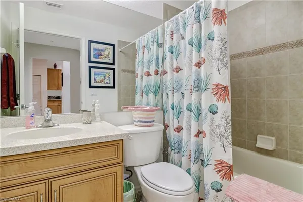 a bathroom with a sink a toilet and shower curtain