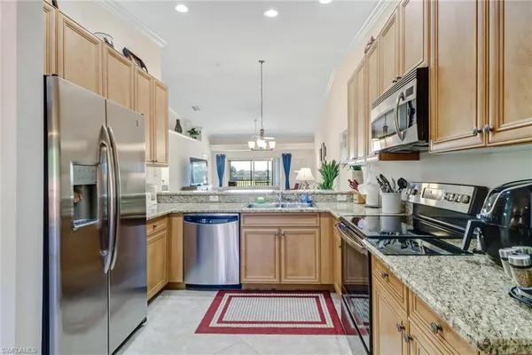 a kitchen with stainless steel appliances granite countertop a sink stove and refrigerator