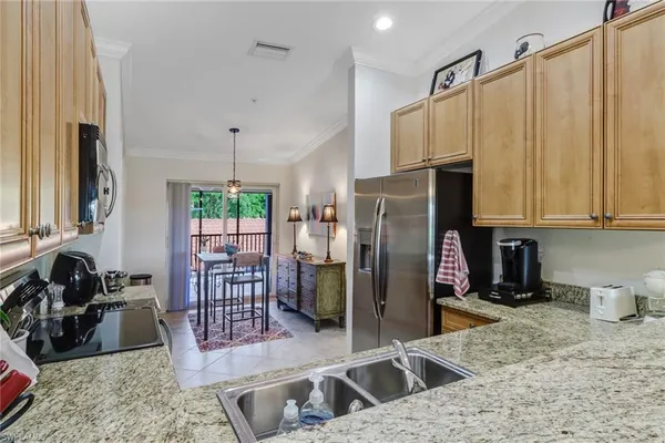 a kitchen with stainless steel appliances granite countertop a refrigerator a stove and a sink with wooden floor