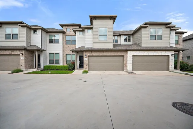 a front view of a house with a garden and garage
