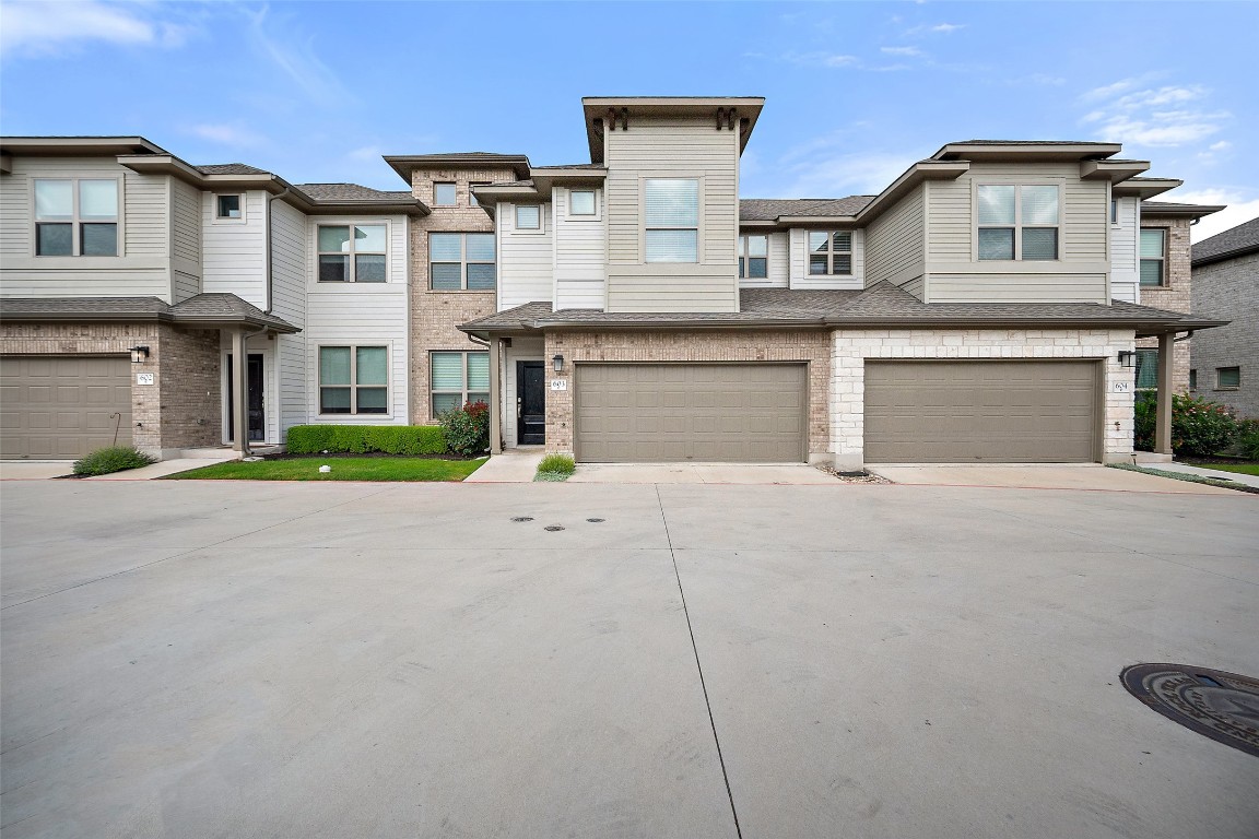 2500 Forest Creek Drive, Unit 603 Round Rock, TX 78665 - Photo 2 of 16 a front view of a house with a garden and garage