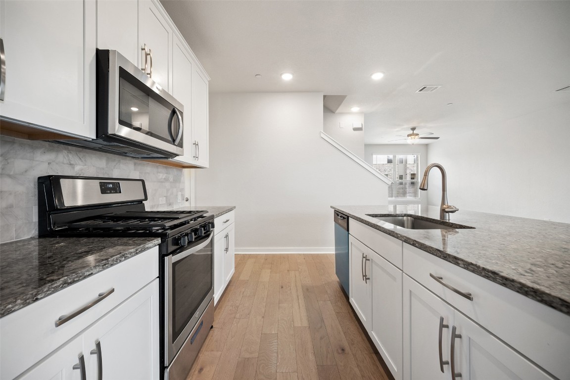 2500 Forest Creek Drive, Unit 603 Round Rock, TX 78665 - Photo 5 of 16 a kitchen with stainless steel appliances granite countertop a sink stove and microwave