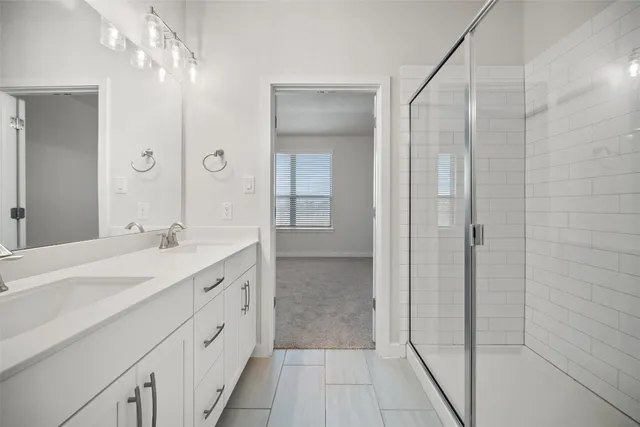 a spacious bathroom with a granite countertop sink a mirror and a shower