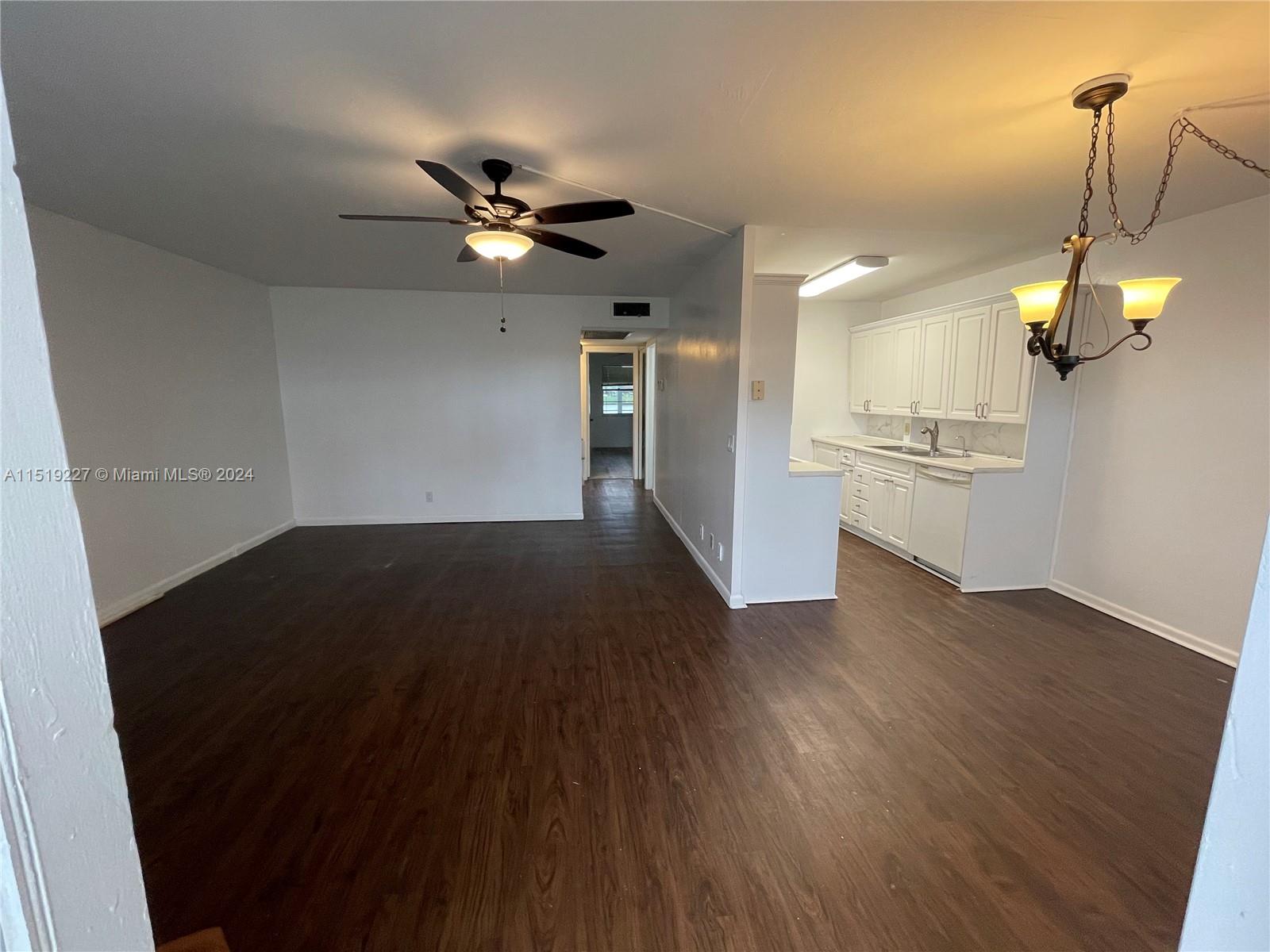 a view of a kitchen with wooden floor and a ceiling fan