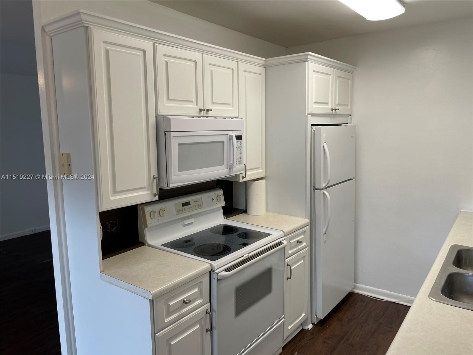 2085 Exeter, Unit 2085 Boca Raton, FL 33434 - Photo 8 of 31 a kitchen with white cabinets and white appliances