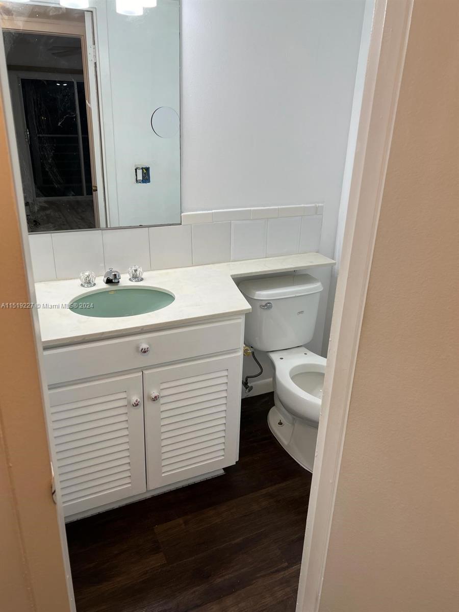 2085 Exeter, Unit 2085 Boca Raton, FL 33434 - Photo 10 of 31 a bathroom with a sink a toilet and a mirror