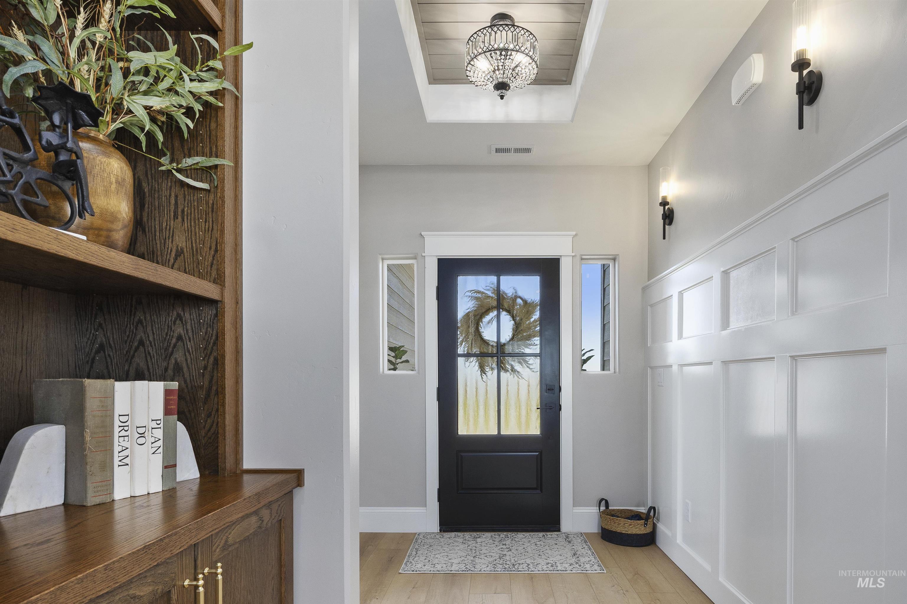 378 West 100 South Rupert, ID 83350 - Photo 4 of 50 Entryway featuring a black paneled door with glass inserts, wood-finish flooring, custom built-in cabinetry, wainscoting, and a decorative ceiling light fixture
