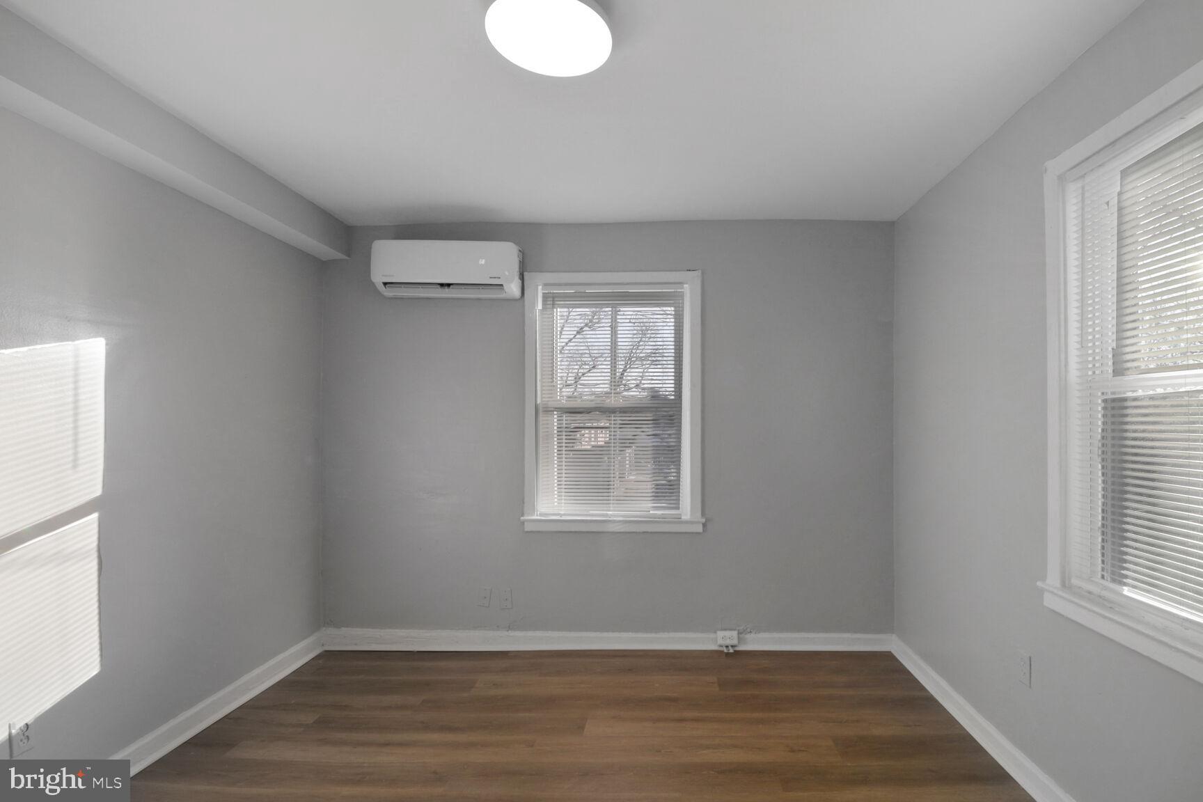 823 Stoll Street Brooklyn, MD 21225 - Photo 4 of 21 an empty room with wooden floor and windows