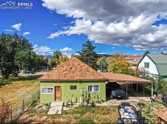 a view of a yard with a table and chairs under an umbrella