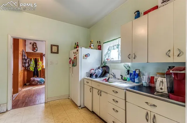 a kitchen with refrigerator and cabinets