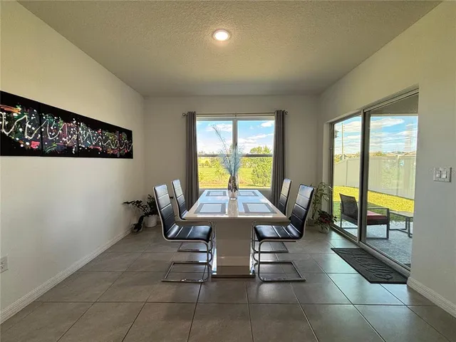 a dining room with furniture and a floor to ceiling window