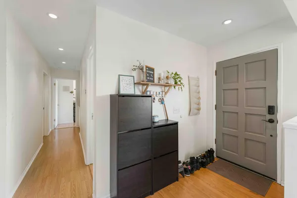 a kitchen with a refrigerator and a wooden floor