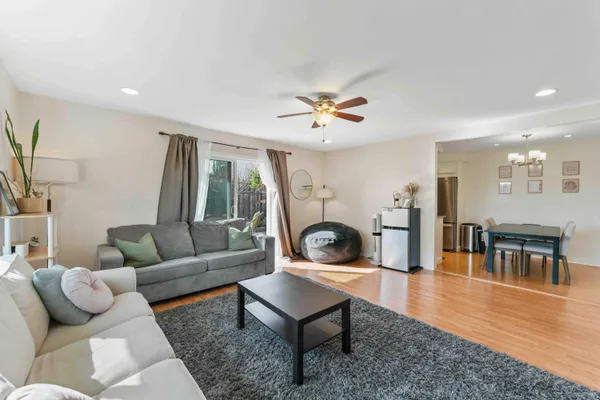 a living room with furniture a table and wooden floor