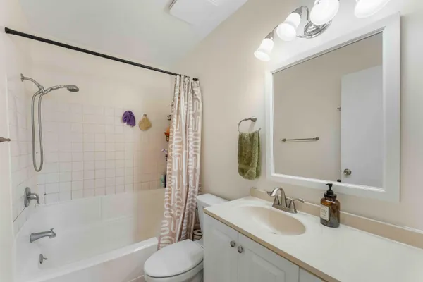 a bathroom with a sink vanity granite tub and shower