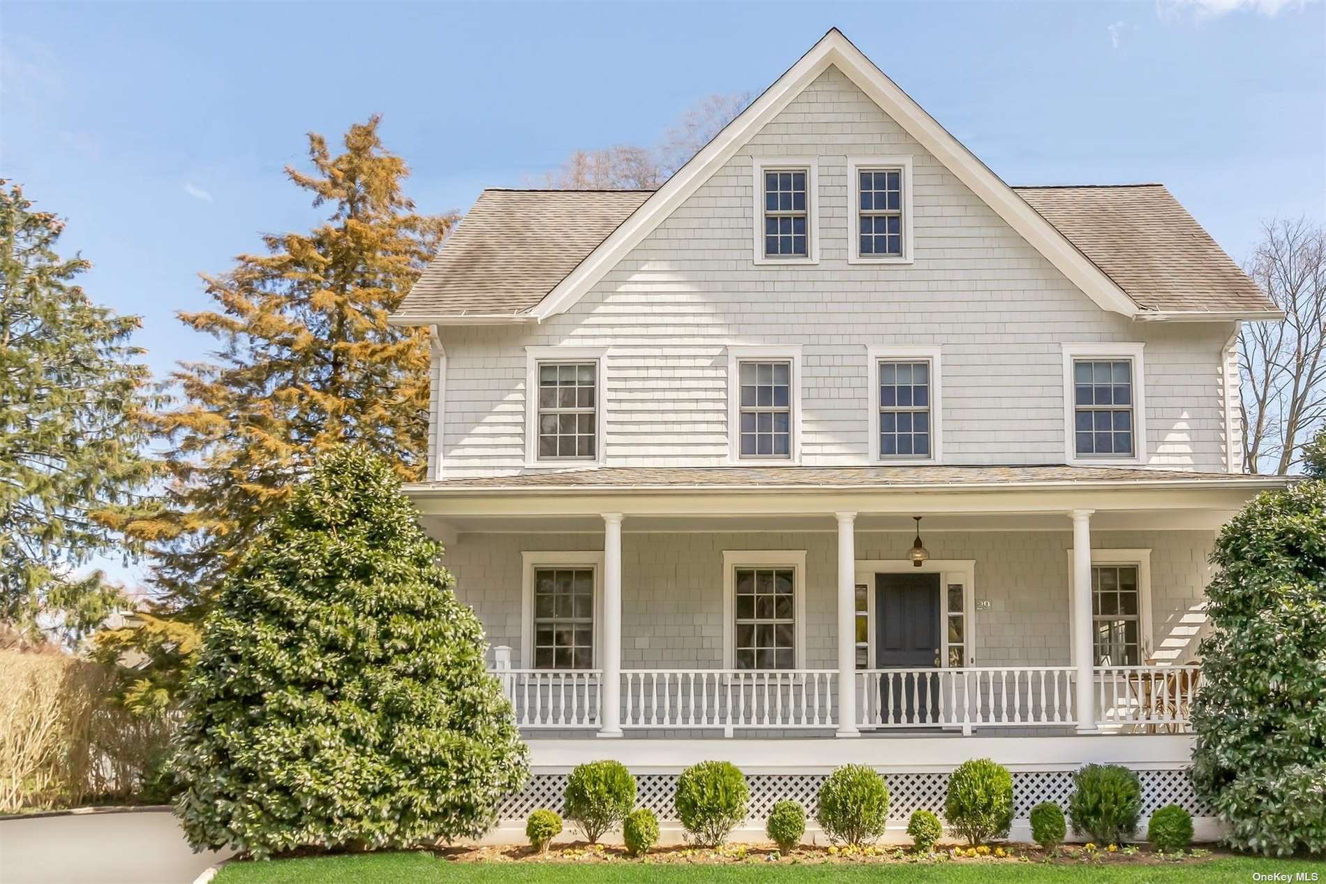 a view of a white house with large windows and a small yard