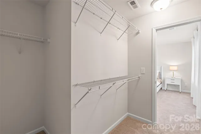 a view of an empty walk in closet and a bathroom