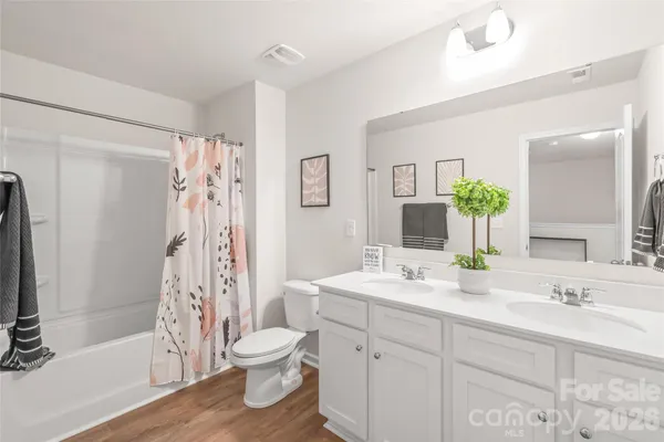 a bathroom with a double vanity sink toilet and shower