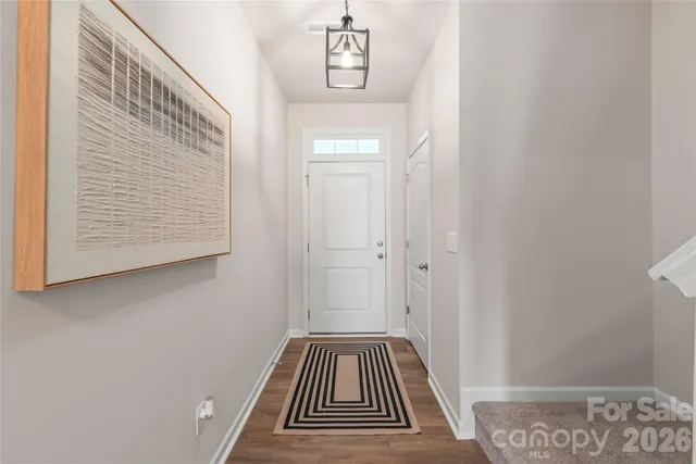 a view of a hallway with wooden floor and a bathroom