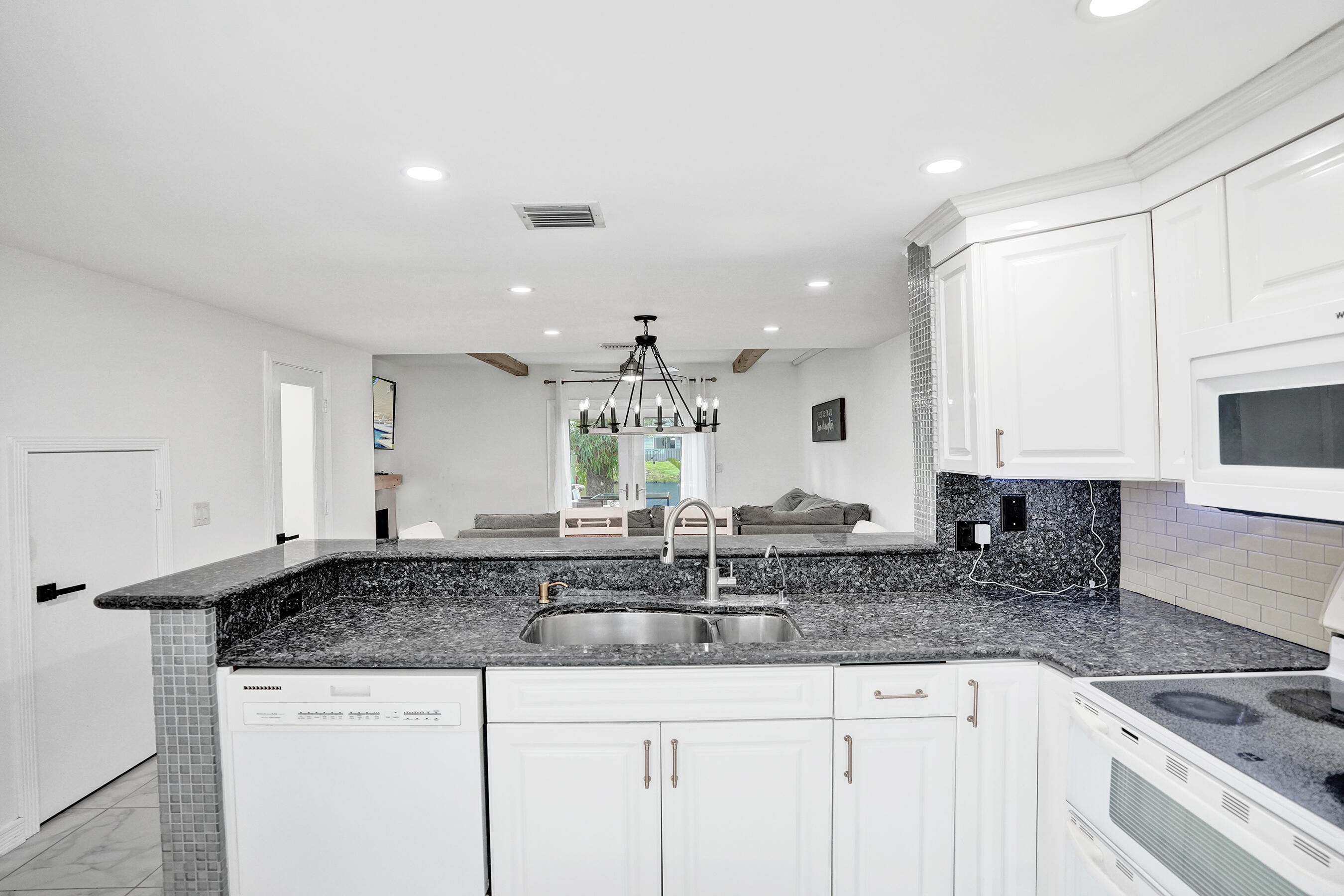 147 Southwest 3rd Street Pompano Beach, FL 33060 - Photo 7 of 29 a kitchen with granite countertop a sink a stove and cabinets